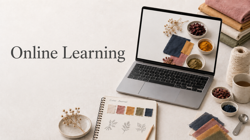 A styled flat-lay scene with a laptop displaying a color/material swatch notebook on screen, alongside a physical swatch notebook, books, thread, small bowls of dried botanicals, and the text 'Online Learning' on a light background.