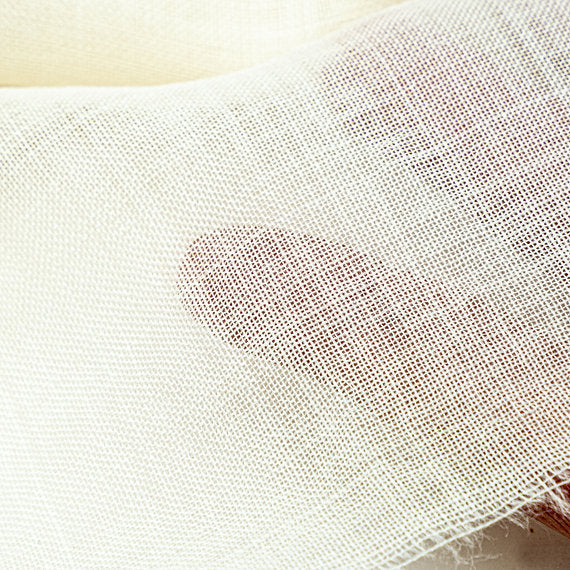 Close-up of a white mesh fabric with a beige background