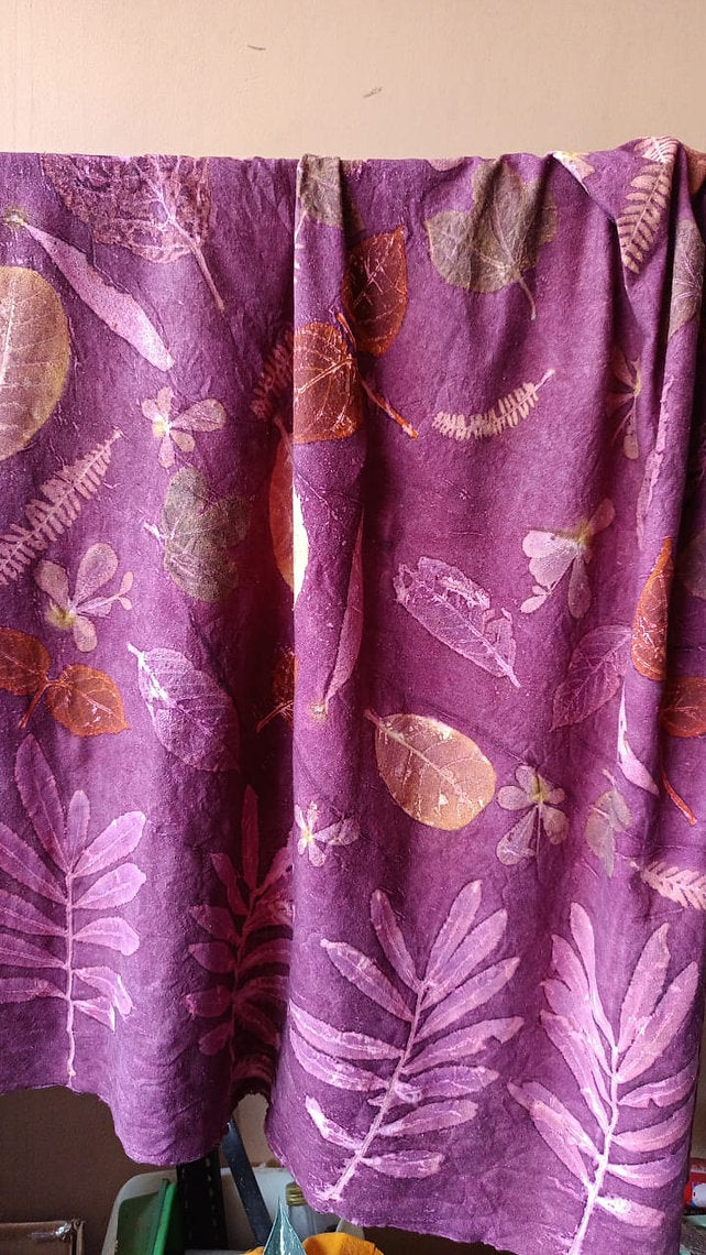 Purple silk fabric with leaf pattern draped over a surface