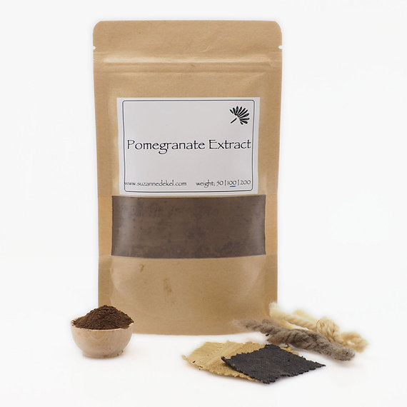 Pomegranate extract package with a spoonful of powder and dried pomegranate pieces on a white background