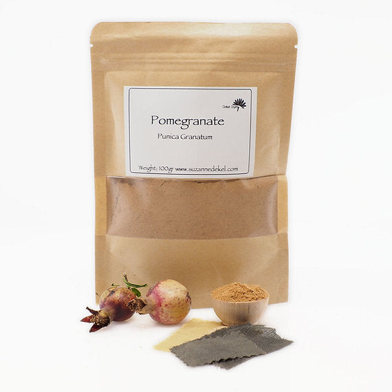 Kraft paper packaging of pomegranate powder with pomegranate fruits and seeds on a white background