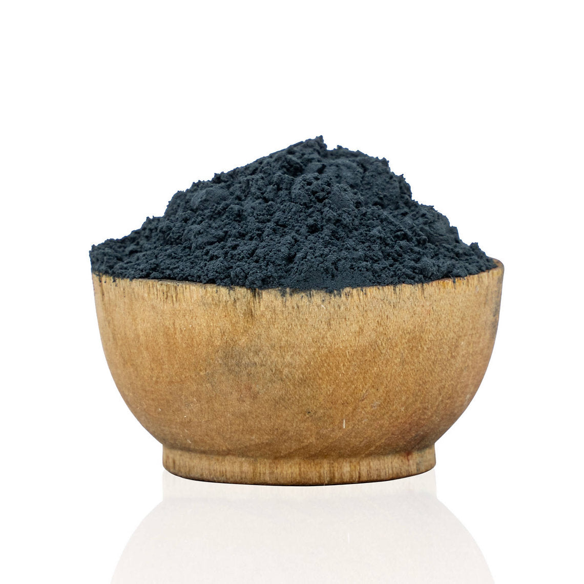 Wooden bowl filled with dark blue powder on a white background