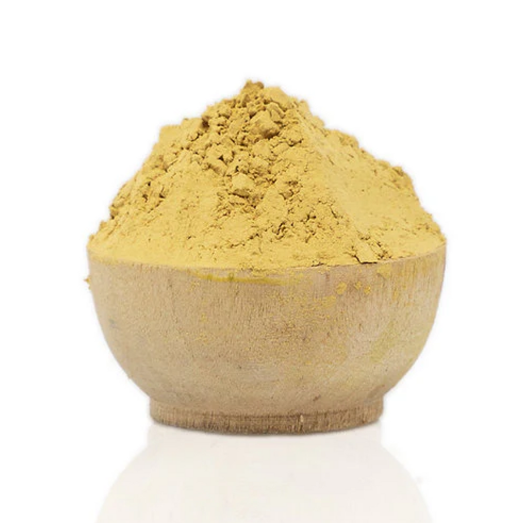 Wooden bowl filled with yellow powder on a white background
