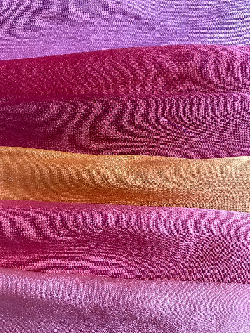 Close-up of fabric with purple, pink, and orange colors.