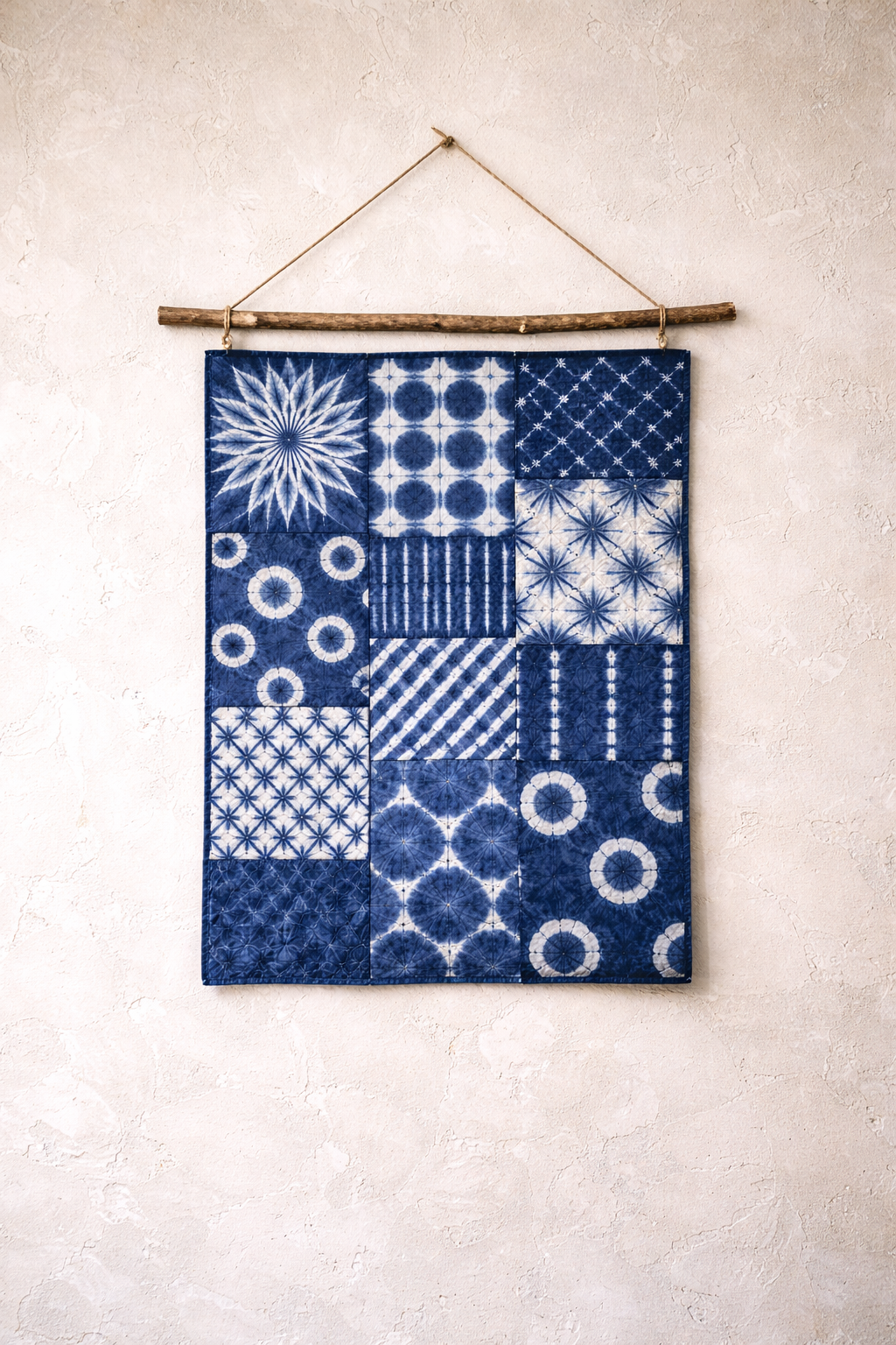 Blue and white patterned fabric hanging on a wooden rod against a light wall.