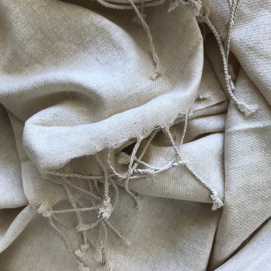 Close-up of beige silk scarf with frayed edges