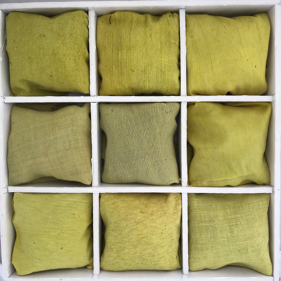 Nine green and yellow fabrics dyed St. Johnswort (Hypericum perforatum) arranged in a 3x3 grid on a white background