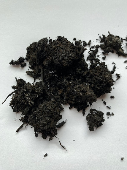Pile of dark soil or compost on a light background