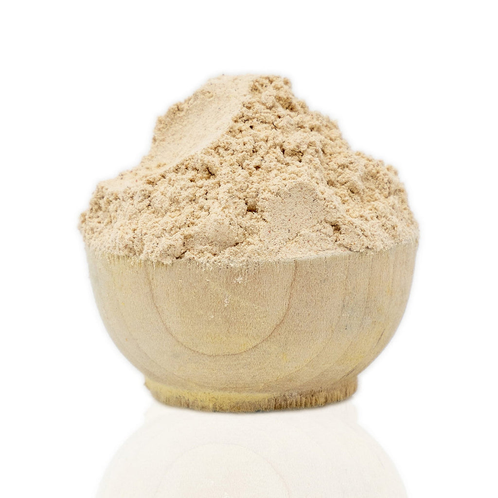 Wooden bowl filled with beige Tara Powder (Caesalpinia Spinosa) on a white background