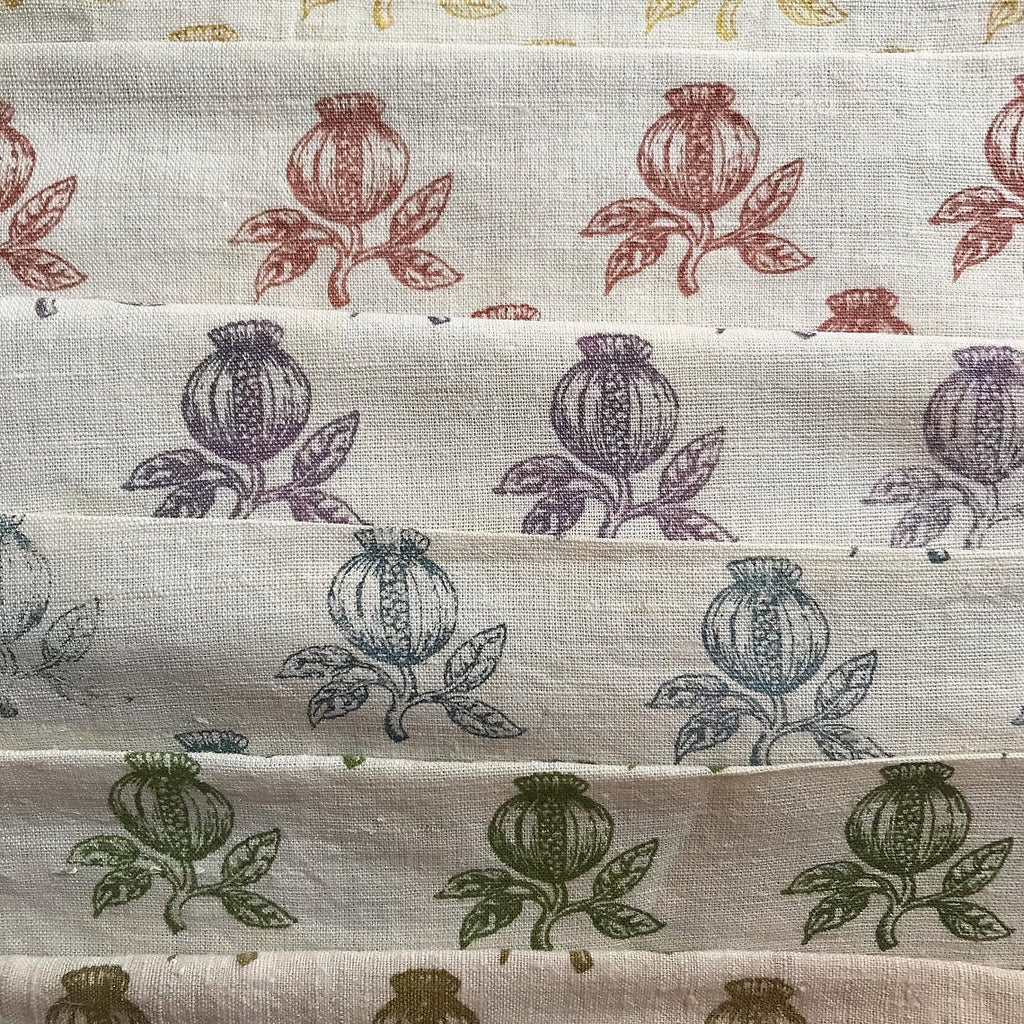 Stack of fabric swatches with floral patterns in various colors.