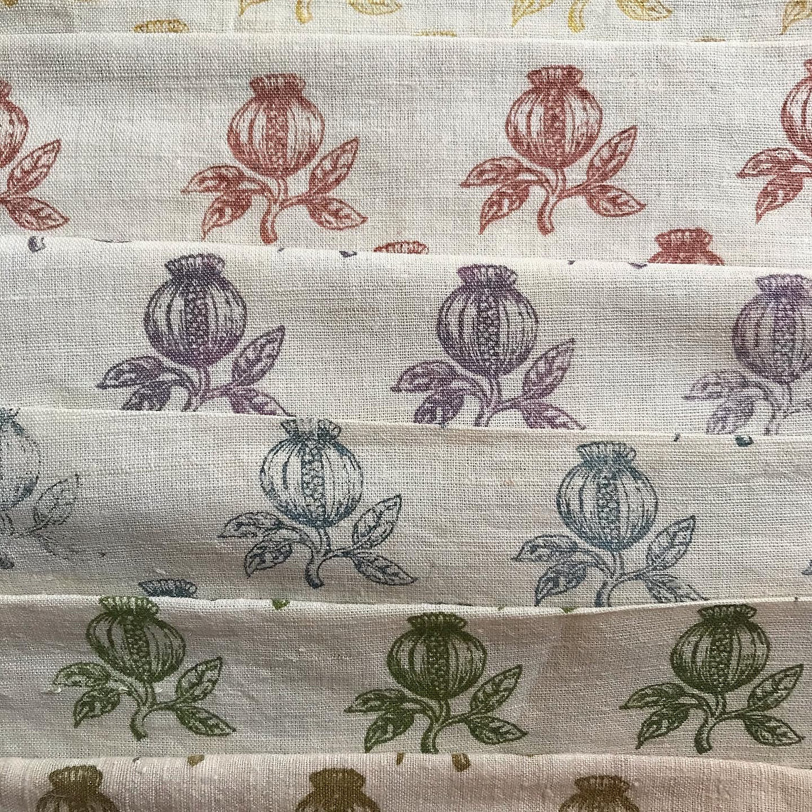 Stack of fabric swatches with floral patterns in various colors.