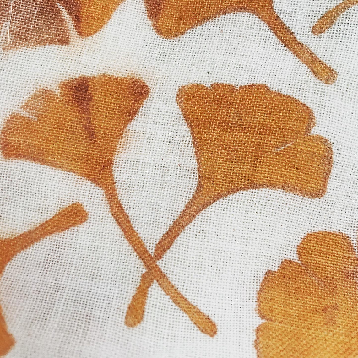Close-up of fabric with brown leaf pattern on a white background
