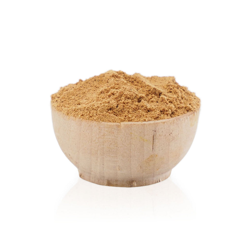 Wooden bowl filled with brown powder on a white background