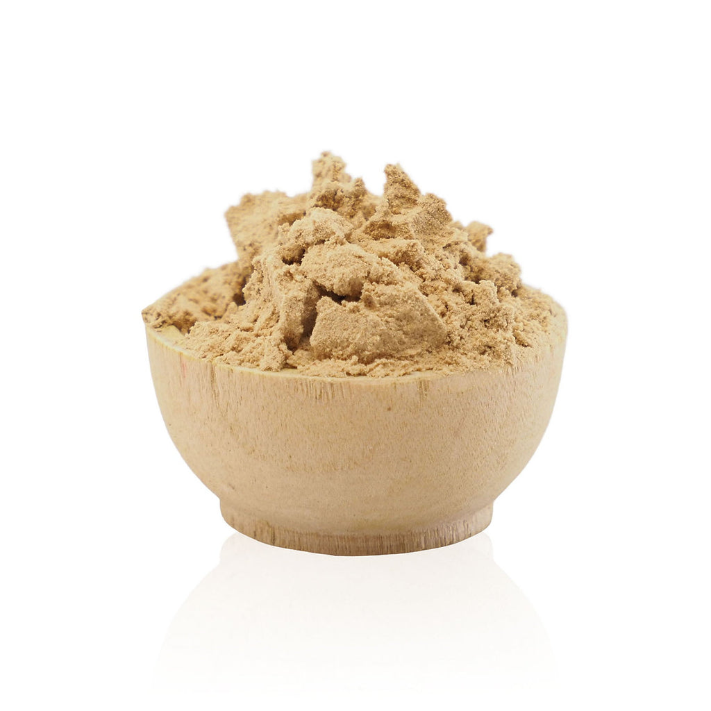 Wooden bowl filled with brown powder on a white background