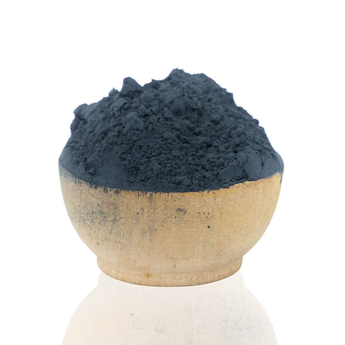 Ceramic bowl filled with dark blue Woad Powder (Isatis Tinctoria) on a white background