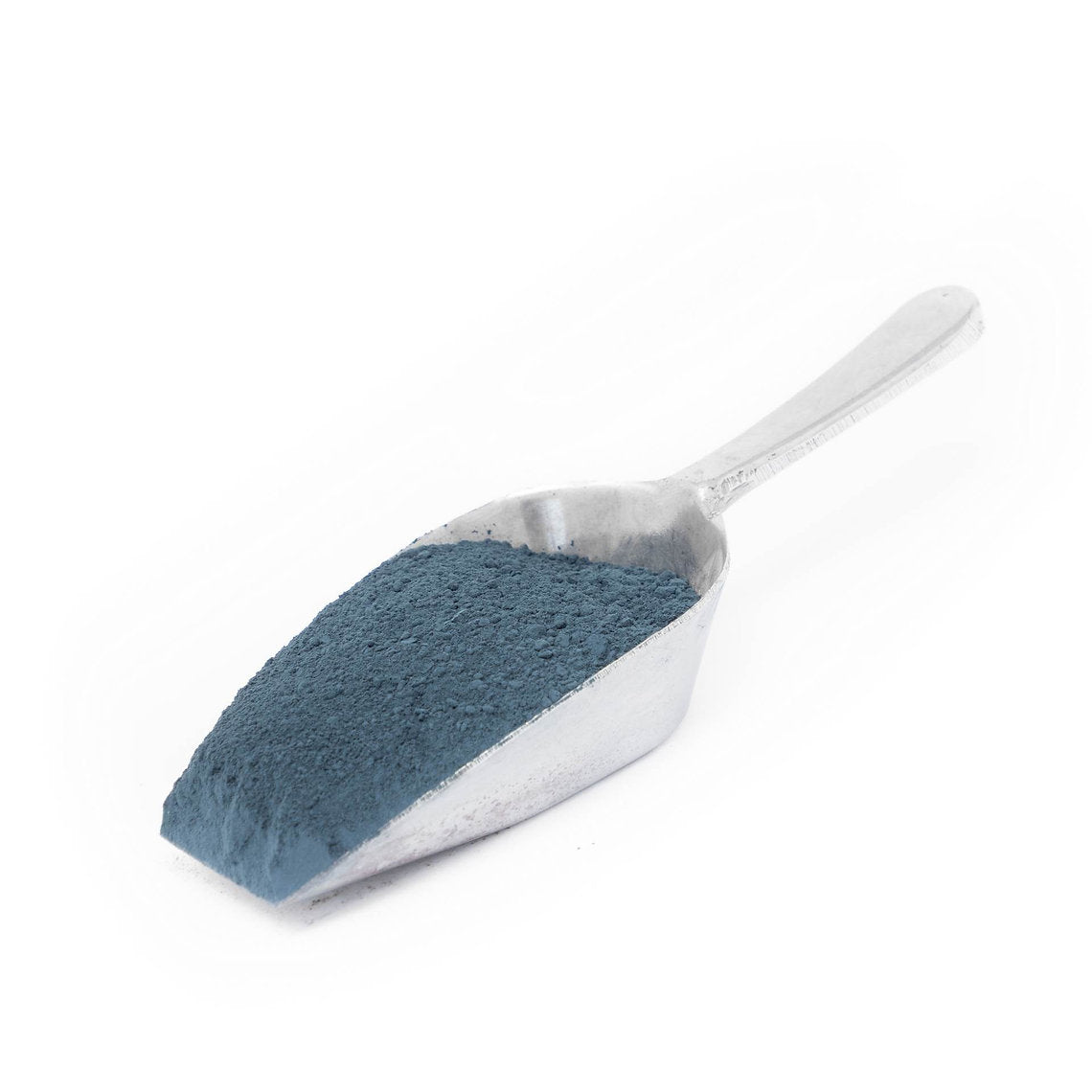 Metal scoop filled with blue Woad Powder (Isatis Tinctoria) on a white background