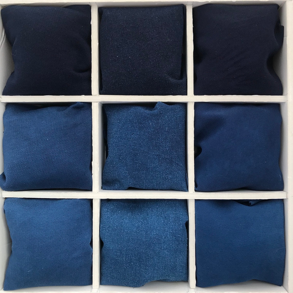 Nine blue fabrics arranged in a 3x3 grid on a white background
