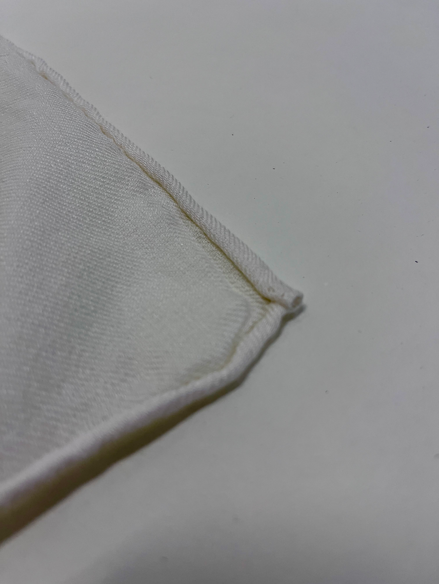 Close-up of a white fabric corner on a light gray background
