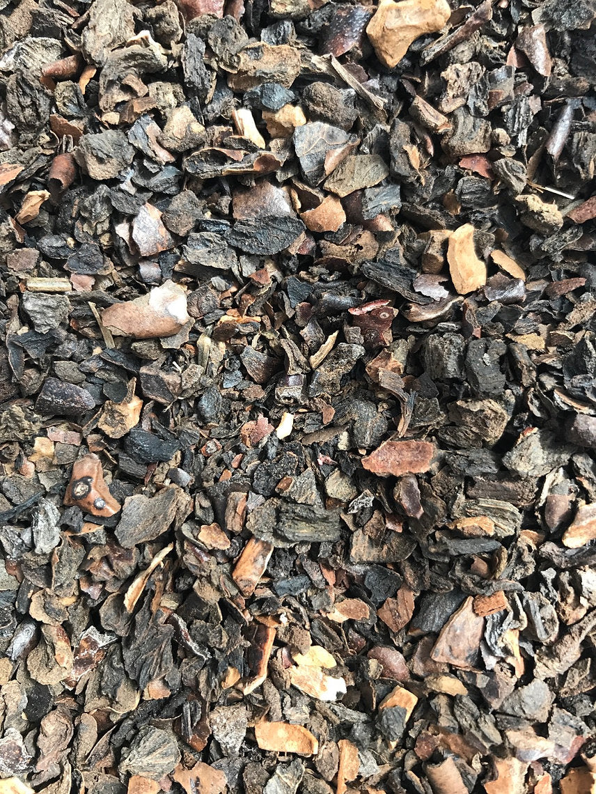 Close-up of a pile of small Black Walnut Hulls (Juglans Negra) and pebbles in various colors.
